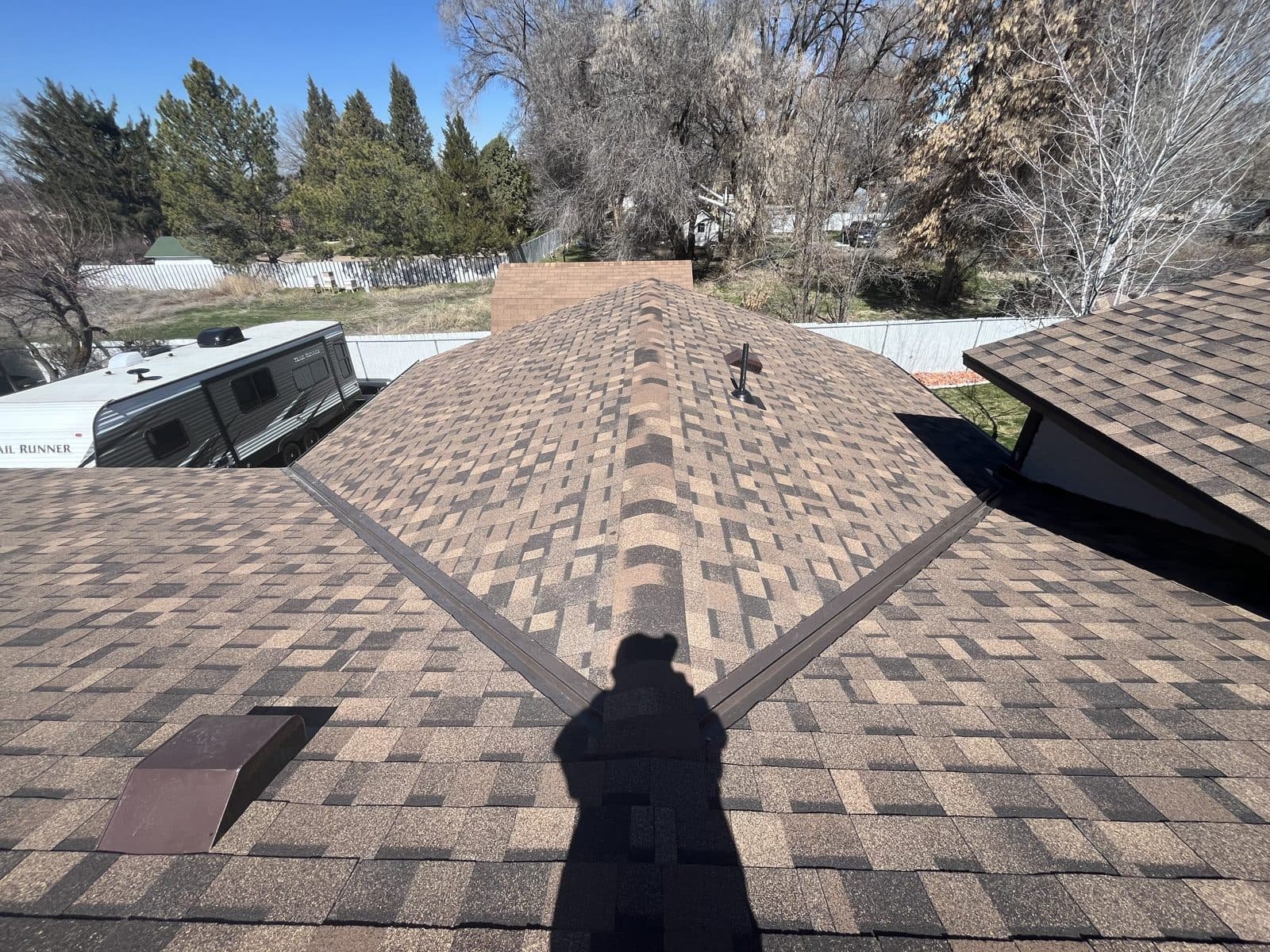 Finished architectural shingle roof with a metal valley, photographed from above.