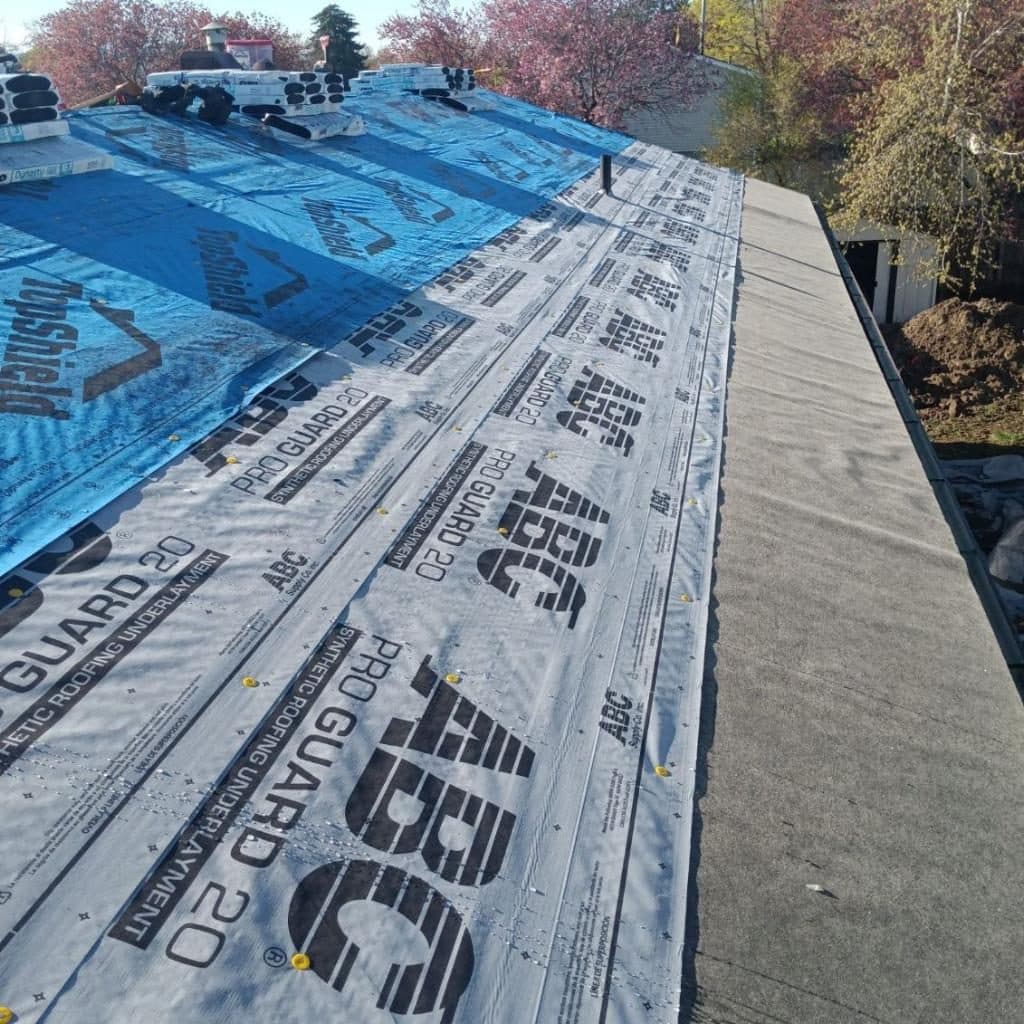 Synthetic underlayment on a roof with ice-and-water shield along the eave.